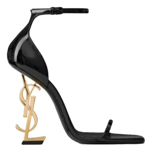 Svarta YSL klackar med gulddetalj -  svarta klackar  YSL med ikonisk guldfärgad logoklack. Snygg minimalistisk design med smal rem över tårna och justerbar ankelrem. Skorna är i glansigt skinn och har en spetsig siluett som verkligen sticker ut. Aldrig använt storlek 39