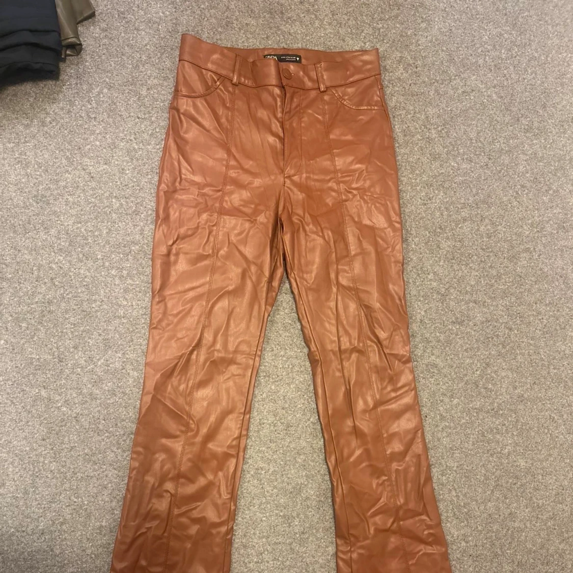 Bruna bootcut byxor i skinnimitation