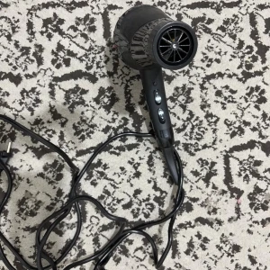 1015 Power 1800W Hårfön - Kraftfull hårfön med 1800W effekt, svart design och ergonomiskt handtag. Utrustad med två hastighetsinställningar och lång sladd för enkel användning. Fint skick, inga synliga defekter eller slitage. Perfekt för snabb och effektiv hårtorkning hemma.