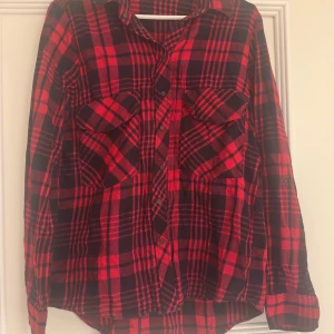 Röd och svart rutig skjorta Zara Woman - Riktigt snygg röd och svart rutig skjorta från Zara Woman. Skjortan har klassisk krage, två bröstfickor med lock och knappar framtill. Perfekt oversized look och tillverkad i mjuk bomull. Långärmad och passar grymt till jeans eller leggings.