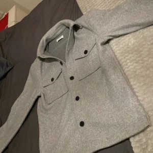 Grå overshirt från studio Total - Tvör fet overshirt från studio total ligger på runt 799-599 på deras hemsida! Den är helt ny knabbt några tecken på användning den passar Xs och S är 175 59kg och den passar mig rätt så perfekt,skriv vid funderingar eller om ni vill ha fler bilder