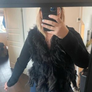 Svart fluffig pälsväst från NORR - Säljer en svart pälsväst från NORR i storlek 40. Västen har en riktigt fluffig och mjuk look.