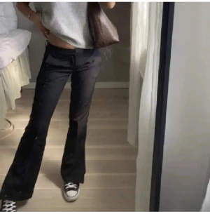 Svarta bootcut kostymbyxor - Snygga svarta kostymbyxor med slits från bikbok med bootcut passform och låg midja. Säljs ej längre. 