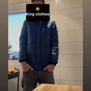 Mörkblå dunjacka från Calvin Klein - Säljer en mörkblå dunjacka från Calvin Klein med huva och diskret CK-logga på ärmen. Jackan har lång ärm, dragkedja framtill och en clean, quiltad look. Perfekt för dig som vill ha en stilren och varm jacka med snygg passform.Jackan har en defekt som ni ser på  höger arm men inget som syns så mycket och går att laga eller täcka över.Jackan passar många olika storlekar,allt från ~155-175.  | För mer frågor och funderingar kontakta mig✨
