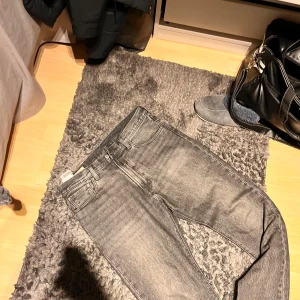 Levi's 551 grå jeans W33 L32 - Säljer ett par Levi's 551 jeans i grå tvättad denim. Klassisk femficksmodell med raka ben och normal passform. Snyggt slitna detaljer och ikonisk läderpatch bak i midjan. Perfekt för dig som gillar vintage-vibe och streetstyle.