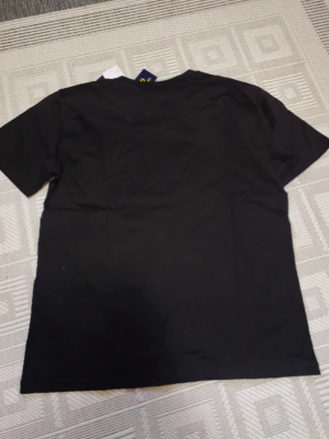 Svart t-shirt PRL - Svart t-shirt från PRL med klassisk röd broderad logga på bröstet. Modellen är slim fit och har rund hals samt korta ärmar. Tillverkad i mjuk bomull för skön känsla. Perfekt för dig som gillar stilrena och ikoniska plagg.