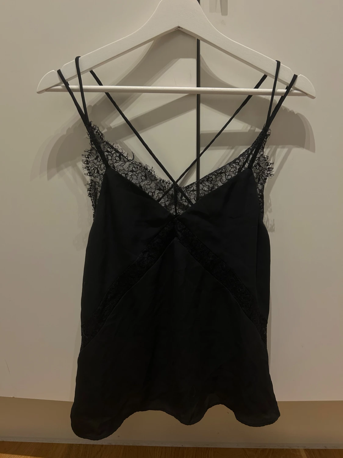 Svart linnetopp med spetsdetaljer