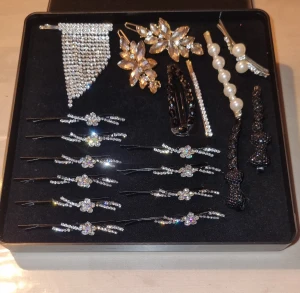 Set med glittriga hårspännen och klämmor - Säljer ett lyxigt set med hårspännen och klämmor i silver, guld och svart. Innehåller pärlspännen, blommiga och glittriga detaljer samt strass. Perfekt för att ge din frisyr extra bling och stil. Flera olika former och mönster, bland annat blomformade och pärlklädda spännen.