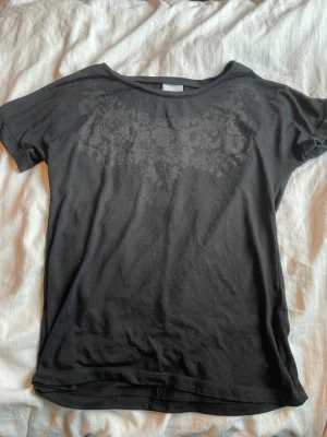 Svart topp T-shirt med mönster  - Svart topp T-shirt från vila storlek s