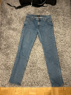 Lee jeans - Blåa Lee jeans i bra skick. Passformen är slim och sitter bra.