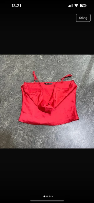 Röd satin linnetopp från SHEIN - Snygg röd linnetopp från SHEIN i storlek XS. Toppen har tunna axelband och är tillverkad i glansigt satinmaterial som ger en lyxig känsla. Modellen är croppad med draperad front för extra stilpoäng. Perfekt för dig som vill sticka ut med färg!