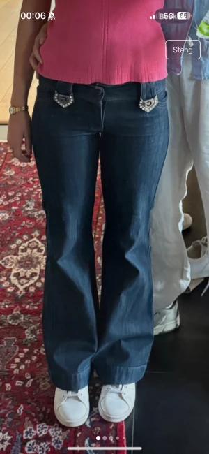 Mörkblå bootcut jeans med strassdetaljer - Köpta på secondhand. Så sjukt snygga! Midjemått: 37cm. Innerbenslängd: 78cm