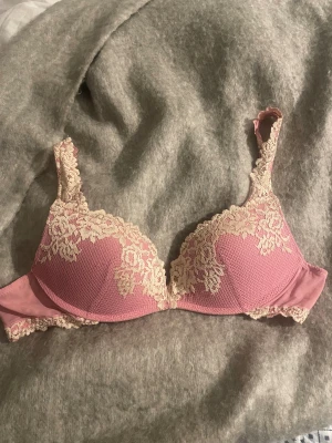 Pretty flowers bh intimissimi - Supersöt rosa bh med krämfärgad spets och blommönster över kuporna och axelbanden. Toppen har justerbara axelband och mjuk vaddering för extra komfort. Perfekt för dig som gillar romantiska detaljer och en feminin vibe. Passar mig som har 75C bra också