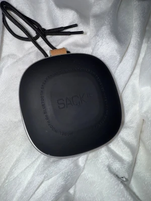 SACKit WOOFit Go Bluetooth-högtalare - Stilren och portabel SACKit WOOFit Go Bluetooth-högtalare i fint skick. Grå textilfront, silverram och praktisk bärrem. Laddas via micro-USB (5V). Perfekt för musik på språng, med tydliga knappar och snygg dansk design. Inga synliga defekter eller större slitage. Nypris 800kr kom med bud !!!