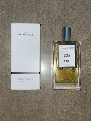 The Essence Vault 939 Fire EdP 100ml - Parfymen The Essence Vault 939 Fire Eau de Parfum kommer i en stilren, rektangulär glasflaska med silverfärgad spraykork. Doften levereras i en vit kartong med minimalistisk design. Flaskan rymmer 100 ml och innehållet har en gyllene ton. ( Dupe på maison margiela by the fire place )