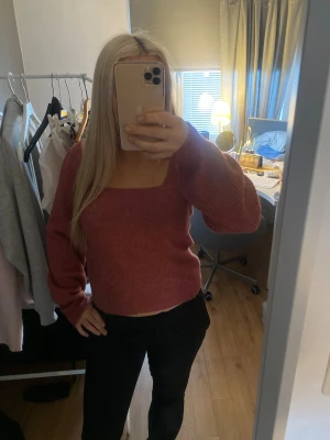 Mörkrosa stickad tröja med fyrkantig ringning - Säljer en mörkrosa stickad tröja med lång ärm och snygg fyrkantig ringning. Tröjan är ribbstickad och har en croppad passform som ger en trendig look. Perfekt att matcha med höga jeans eller kjol. Materialet känns mjukt och bekvämt mot huden.