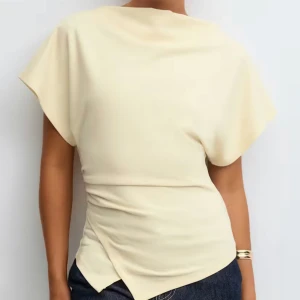 Gul topp från Gina - Snygg gul topp med omlott-detalj i midjan och korta ärmar. Toppens mjuka material och asymmetriska nederkant ger en cool och modern vibe💞💞💞