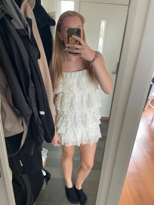 Studentklänning Zara - Supersöt vit kort klänning från Zara med flera lager volanger och spetsdetaljer. Passar en S-M.