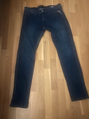 Mörkblå raka jeans - Snygga mörkblå jeans med klassisk femficksdesign och raka ben. Jeansen har kontrastsömmar och en enkel knappstängning framtill. Perfekta till en avslappnad stil och passar till det mesta i garderoben.