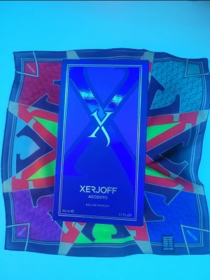 Xerjoff Accento Eau de Parfum 50ml - (Köp nu bara, inga bud) Xerjoff Accento Eau de Parfum i en lyxig blå och lila kartong med metallic-detaljer. Den rymmer 50 ml, 2 sprays, helt ny och är känd för sina exklusiva och unika noter.