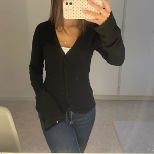 Svart söt kofta med knappar - En svart söt kofta med knappar och utsvängda ärmar längre ut. Den har en figurnära passform och spetsdetaljer längst ut på ärmarna och utemed kanterna. Xs men passar även S och M🙏🏼💖