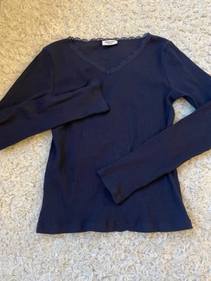Mörkblå ribbad topp med spets🩵 - Mörkblå långärmad topp från Kappahl med v-ringning dekorerad med spetskant. Materialet känns mjukt och stretchigt.           OBS! Bilderna är tagna i olika ljus, bild 1 är i dagsljus🧡