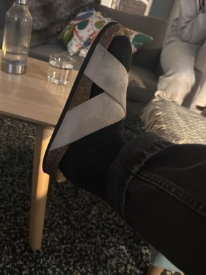  tofflor med kokos - Snygga tofflor med breda beige remmar i mocka och en klassisk korksula. Platt sula och öppen tå ger en avslappnad vibe. Perfekta för att chilla hemma eller hänga med kompisar.