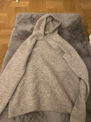 Grå hoodie från Ahlquist Clothing - Mysig ljusgrå hoodie från Ahlquist Clothing i storlek XS. Tillverkad i mjukt stickat material med ribbade muddar vid ärmslut och nederkant. Klassisk huva och avslappnad passform, perfekt för chill dagar.