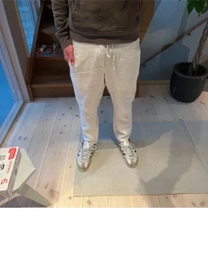 Beiga linnebyxor med snörning - Snygga beiga linnebyxor med avslappnad passform och dragsko i midjan. Köpa för 799 använda en gång.