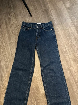 Mörkblå raka jeans från Gina tricot - Snygga mörkblå jeans från Gina tricot med klassisk femficksdesign och raka ben. Jeansen har normal midja och är tillverkade i robust denim av bomull. Perfekta för en clean och enkel stil.