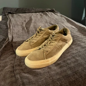 Beige mockasneakers från Massimo Dutti - Snygga sneakers i beige mocka från Massimo Dutti med klassisk design och snörning. Skorna har en platt, ljus sula och rund tå. Perfekta för dig som gillar stilrena och neutrala färger. Ovandelen är i mjuk mocka och insidan i skinn för extra komfort. Nypris är 1200. Perfekta för sommaren, våren och hösten.