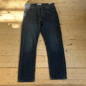 Jack & Jones Loose Chris jeans blå - Säljer ett par blå jeans från Jack & Jones, modell Loose Chris. Jeansen har loose fit, raka ben och klassisk femficksdesign. Tillverkade i denim av bomull med dragkedjegylf och snygga kontrastsömmar. Perfekta för en avslappnad stil. W28 L30