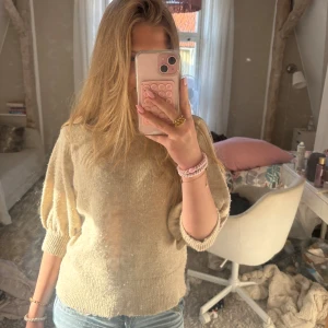Beige stickad tröja från Vila - Supermysig beige stickad tröja från Vila med rund hals och puffade trekvartsärmar. Tröjan har ribbade muddar vid hals, ärmslut och nederkant. Använd bara några gånger, storlek M men funkar jätte bra som S