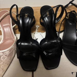 Svarta klackskor från Zara - Snygga svarta klackskor från Zara med smala remmar och fyrkantig tå. Helt oanvända och väldigt fina!!