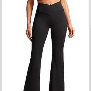 Svarta bootcut träningsbyxor med fickor - Svarta bootcut träningsbyxor med hög midja och snygg V-formad linning. Byxorna har praktiska fickor på sidorna, perfekta för mobilen. Tillverkade i stretchigt syntetmaterial som sitter skönt och följer kroppen. Perfekta för dig som gillar en sportig och trendig look. OÖPPNAD förpackning med prislappen kvar! Har stl S Short. Passar stl S/M. Köpta för 700kr