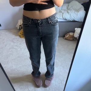Mörkgråa raka jeans - Säljer ett par jeans i mörk grå tvättad denim. Jeansen har rak passform, normal midja och femficksdesign. Perfekta för dig som gillar en tidlös och avslappnad look. Materialet är 100% bomull och de har metallknappar. Jg tycker om dom väldigt mycket men jag säljer pågrund av att jag har för mycket jeans hemma.