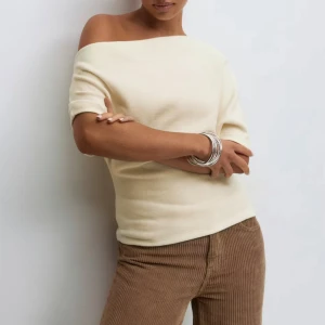 Offshoulder stickad topp i beige - Säljer min Superfin helt oanvända offshoulder topp i ljusbeige stickat material. Tröjan är helt slutsåld från ginatrigot i båda beige och grå. 