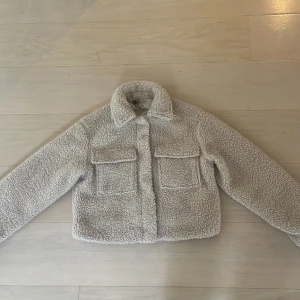 Beige teddyjacka  - Supermjuk och fluffig teddyjacka i beige från H&M Divided. Jackan har två stora bröstfickor, klassisk krage och stängs med tryckknappar. Storlek xxs 💗