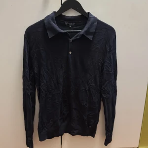 Mörkblå pikétröja från Lageny - Snygg mörkblå långärmad pikétröja från Lageny med klassisk krage och två knappar framtill. Perfekt för dig som gillar stilrena och enkla plagg. Skön passform och passar till många olika outfits.