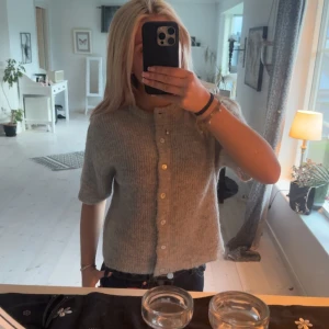 Grå stickad kofta med kort ärm - Supermysig grå stickad kofta med korta ärmar, strlk Xs från Gina, inte kommit till användning så mycket🩷