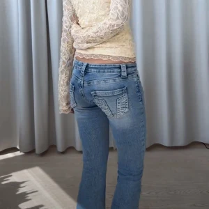 Blå bootcut jeans med låg midja - Andvänd bara två gånger så mycket bra skick, från Gina Young 