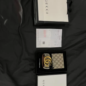 Plånbok och bälte - En plånbok och bälte med box påse och kvitto. 