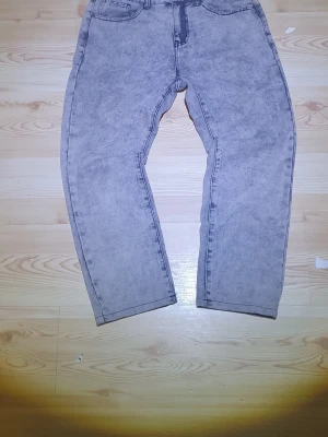 Grå baggy jeans med tvättad look - Säljer ett par grå jeans med tvättad effekt och baggy passform. Byxorna har klassisk femficksdesign, raka ben och normal midja. Materialet är jeans och färgen är en ljusgrå ton med lite sliten känsla. Perfekt för dig som gillar avslappnad stil. Passar också till den blåa pikén jag säljer