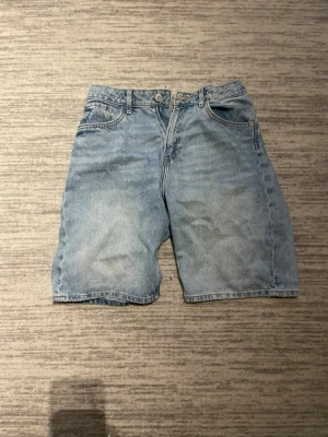 Blå denimshorts med normal passform - Säljer ett par klassiska blå jeansshorts i normal passform. Hm 