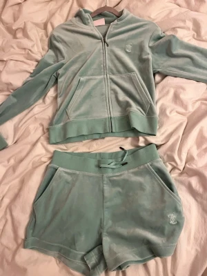 Juicy Couture Sport mintgröna shorts - Mintgröna shorts från Juicy Couture Sport i mjuk velour med broderad logga bak och liten JC-brodyr fram. Shorts med bred resår och snörning i midjan, samt fickor på sidorna. Perfekt för chill eller sportig vibe.