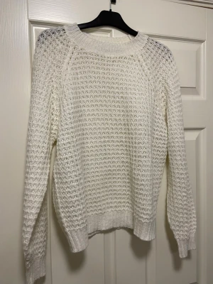 Vit stickad tröja från 157 - Säljer en vit stickad tröja från 157 med grovstickat mönster och rund hals. Tröjan har långa ärmar och ribbade muddar vid ärmslut och nederkant. Perfekt för lager-på-lager under kyliga dagar. Materialet är en blandning av akryl och polyester. Fint skick!