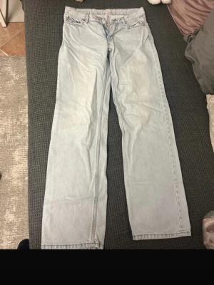 Ljusblå raka jeans - Säljer ett par ljusblå jeans  i rak modell. Klassisk femficksdesign, normal passform och dragkedja med knapp. Jeansen har en enkel look utan slitningar eller mönster, perfekta till vardagsstilen.