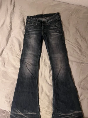 Bootcut jeans från Cheap Monday, blå - Snygga blå bootcut jeans från Cheap Monday med klassisk femficksdesign och kontrastsömmar. Jeansen har låg midja och är tillverkade i en blandning av bomull, polyester och elastan för skön stretch. Faded effekt framtill och bak ger en cool vibe.