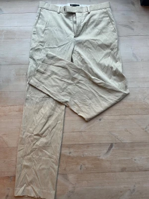 Beige kostymbyxor i linnematerial ASOS DESIGN W34 L34 - Vida finbyxor i krinklat linne. Från ASOS design i färgen beige. Storlek W34 L34