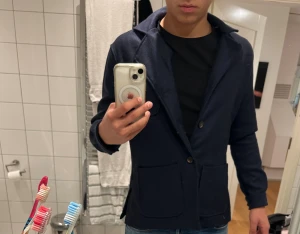 Mörkblå overshirt från John Henric - Snygg mörkblå overshirt från John Henric med två knappar framtill och stora fickor. Klassisk krage och långärmad modell, perfekt för dig som gillar stilrena och enkla plagg. Materialet är mjukt och känns som ull, vilket gör den skön att bära.